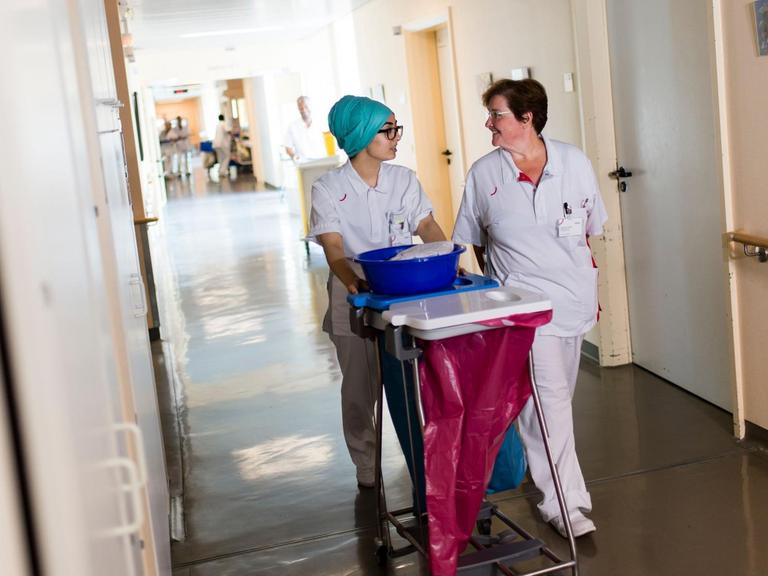 Krankenpflegeschülerin Türkan Deniz und Krankenschwester Marianne Weber laufen durch einen Flur im Vivantes-Humboldt-Klinikum in Berlin.