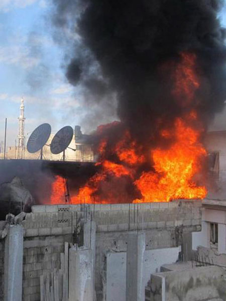 Ein brennendes Gebäude in Homs (Archiv)