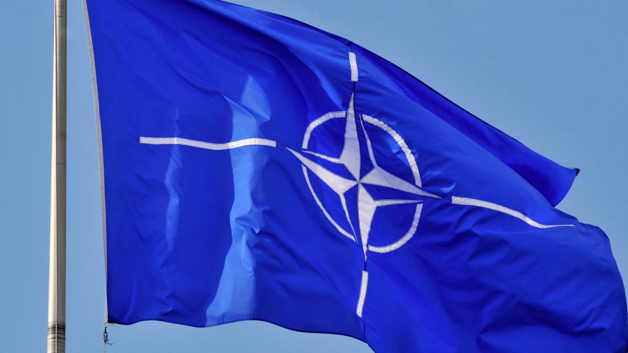 Eine Flagge der NATO weht im Wind.