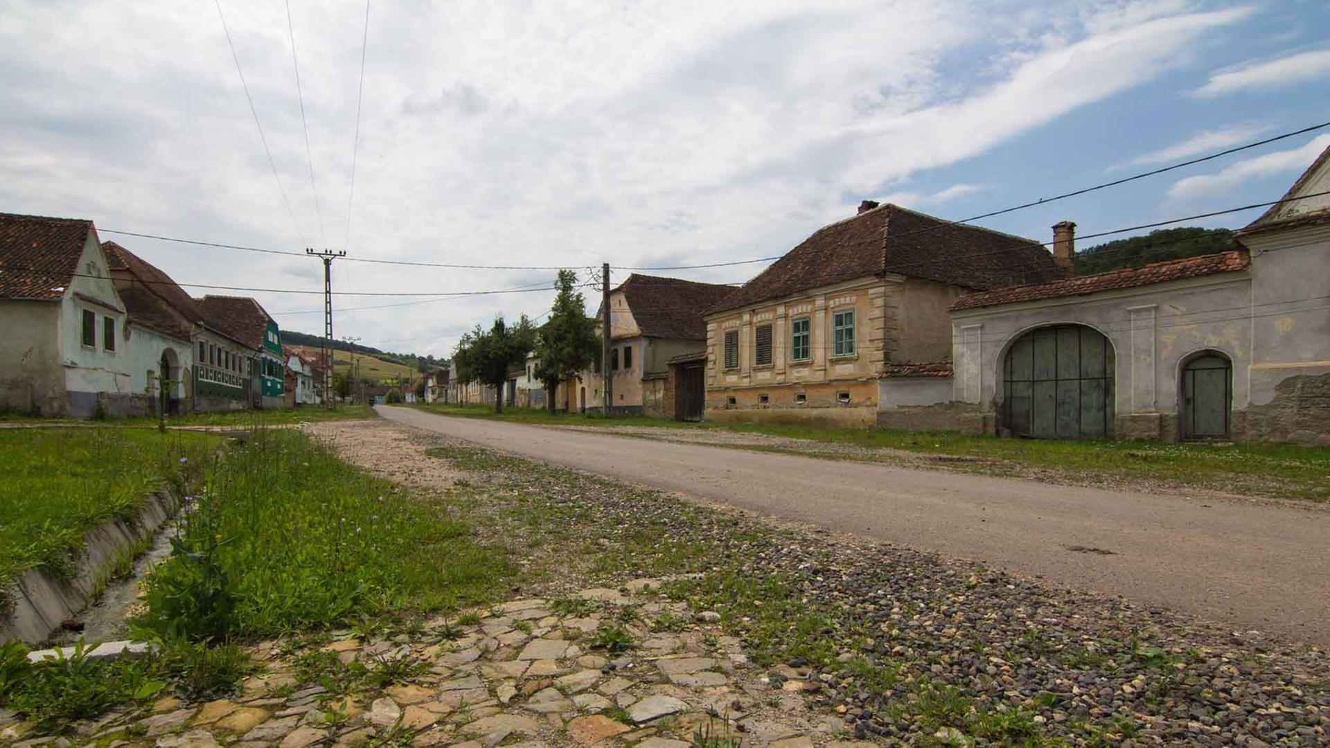 Ein typisches Dorf in Siebenbürgen, Rumänien, mit Dorfstraße und Steinhäusern.