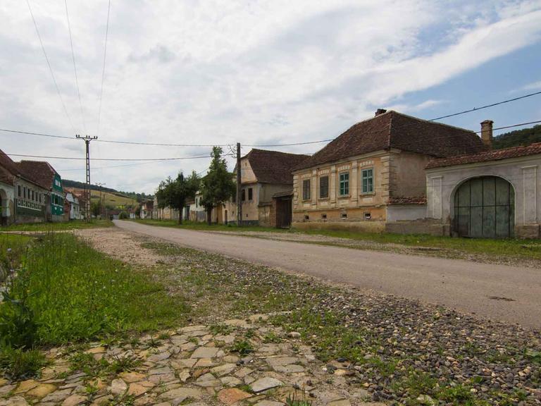 Ein typisches Dorf in Siebenbürgen, Rumänien, mit Dorfstraße und Steinhäusern.