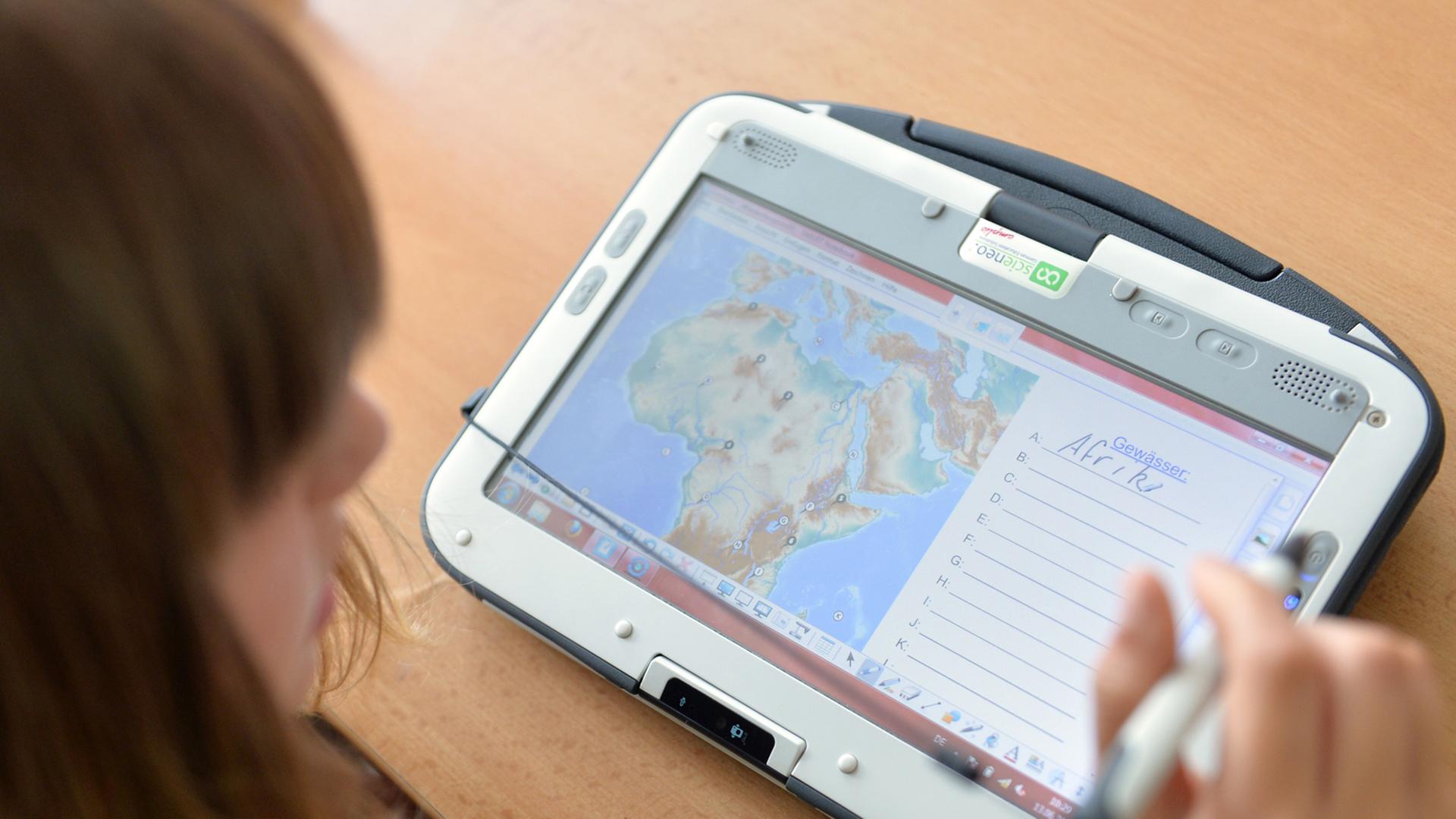 Eine Schülerin arbeitet an Tablet-PC, auf der die Afrika-Karte zu sehen ist.