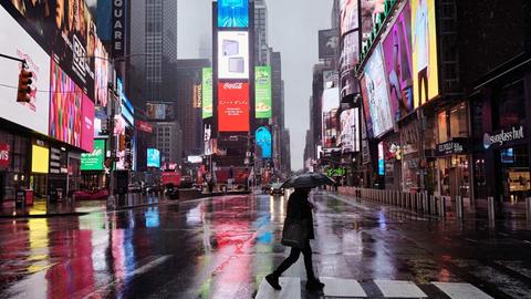 Passant überquert die Straße am weitgehend menschenleeren New Yorker Times Square 