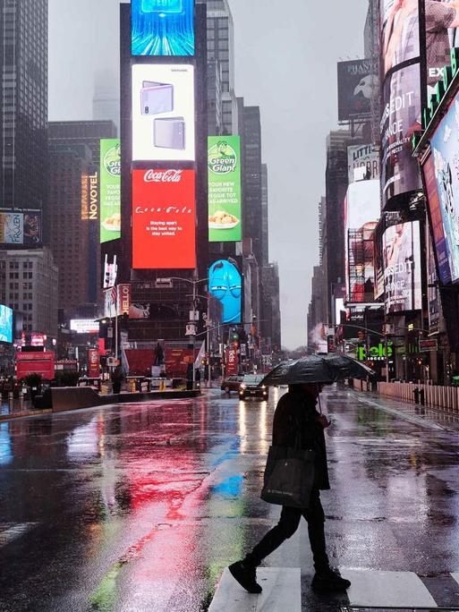 Passant überquert die Straße am weitgehend menschenleeren New Yorker Times Square 