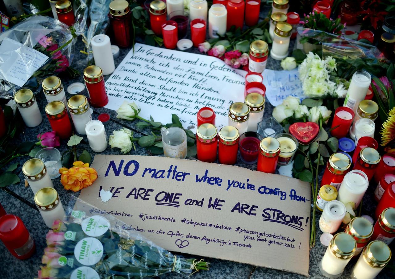 Beileidsbekundungen und Schilder liegen zwischen Blumen und Kerzen am 21.12.2016 in Berlin unweit der Stelle des Anschlags auf dem Weihnachtsmarkt am Breitscheidplatz.