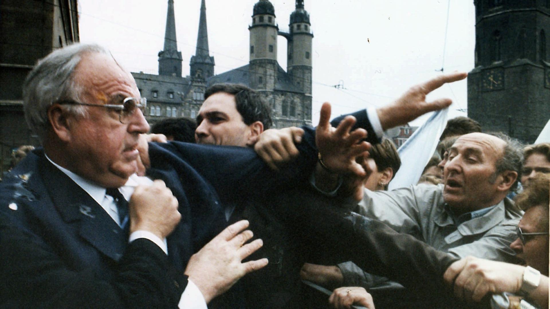 Helmut Kohl wird bei einer Veranstaltung in Halle bedrängt und mit Eiern beworfen.
