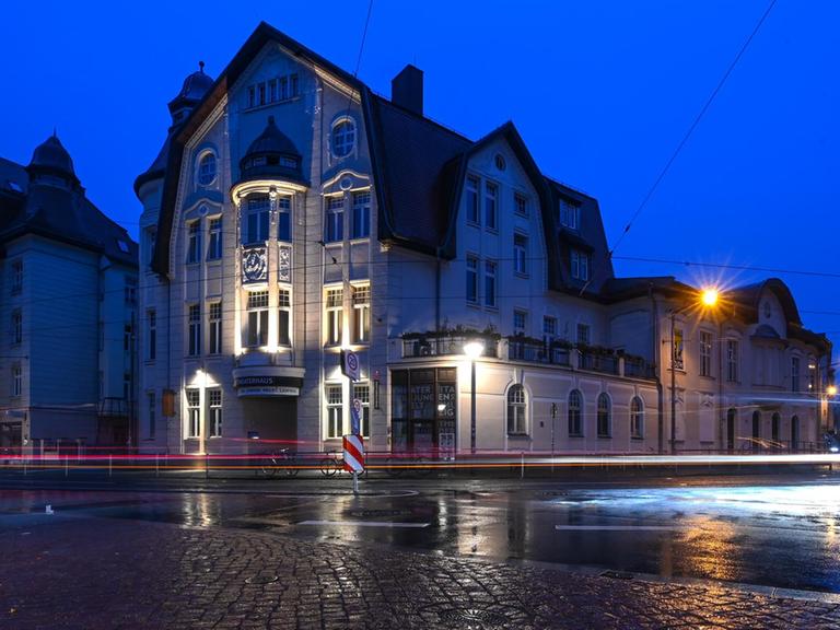 Die Lichter von vorbeifahrenden Autos sind vor dem Theater der Jungen Welt in Leipzig zu sehen.