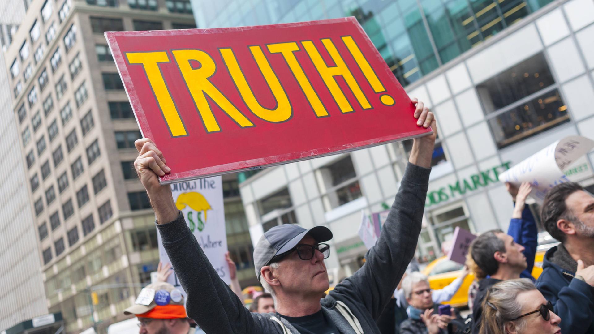 Ein Demonstrant hält ein Plakat mit der Aufschrift "Truth", Wahrheit hoch, bei dem Protestmarsch in New York in Reaktion auf Donald Trumps "Krieg gegen die Medien" am 25. März 2017
