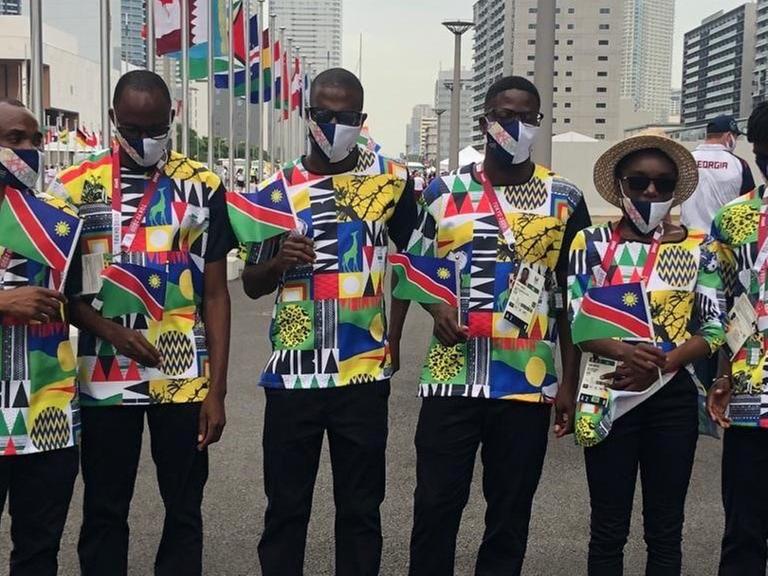Ananias Shikongo (3. von links) mit Teamkollegen. Sie halten Flaggen von Namibia in den Händen.