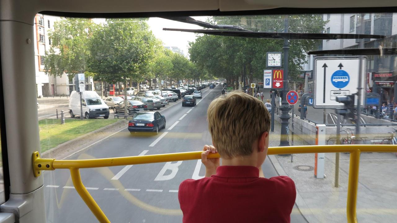 Ein Junge betrachtet vom Oberdeck eines Doppeldecker-Busses das Treiben auf dem Berliner Kurfürstendamm Höhe Adenauerplatz. 