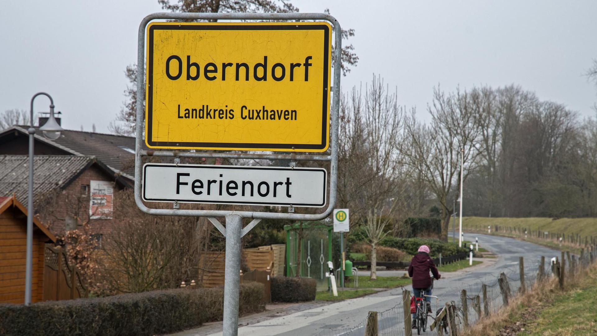 Eine Frau fährt am 08.03.2017 mit dem Fahrrad auf einer Landstraße am Ostedeich in den Ort Oberndorf (Niedersachsen).
