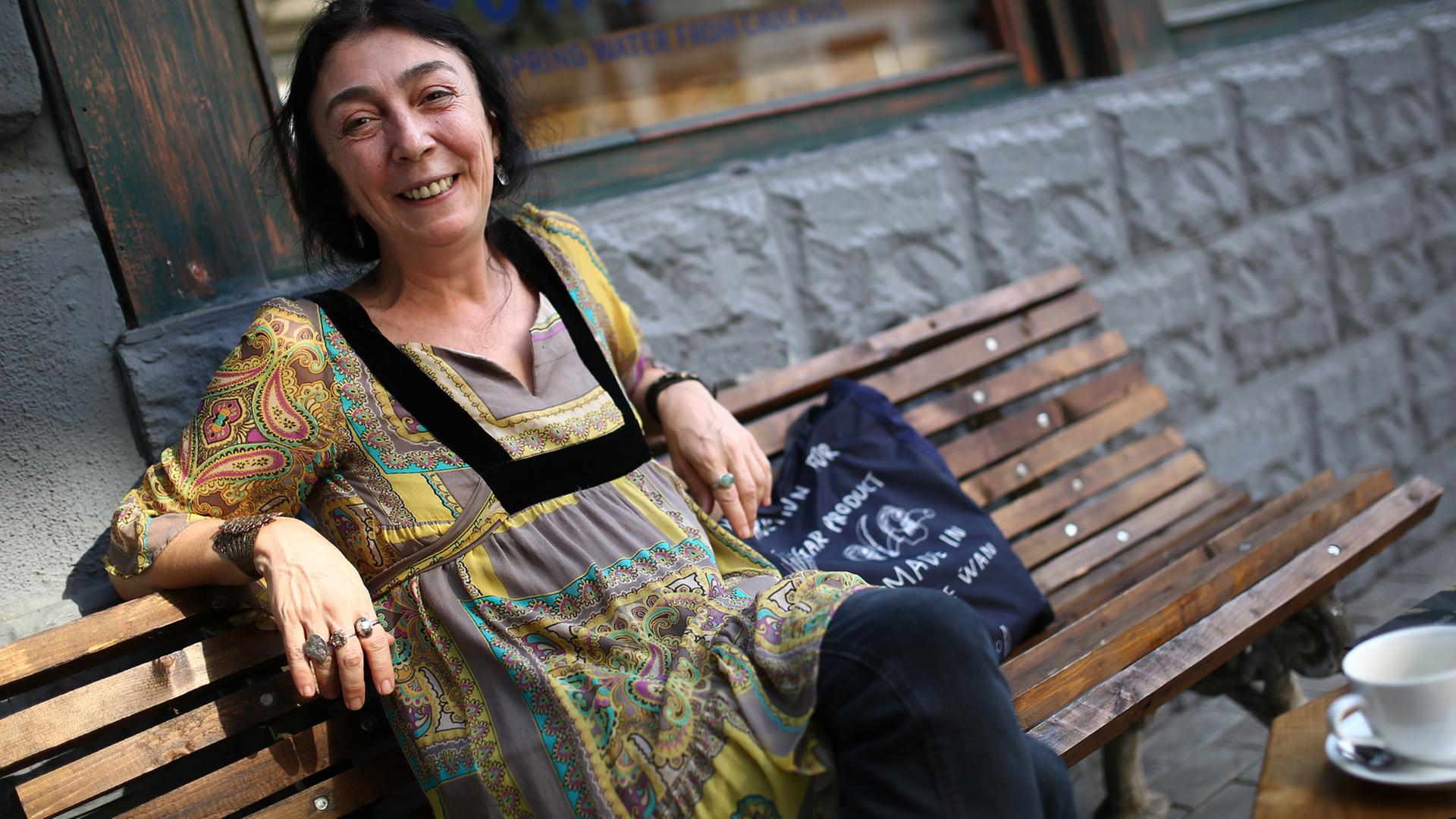 Ana Kordzaia-Samadaschwili sitzt auf einer Bank und lächelt freundlich