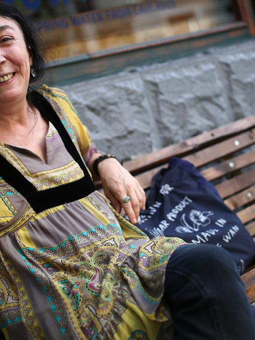 Ana Kordzaia-Samadaschwili sitzt auf einer Bank und lächelt freundlich