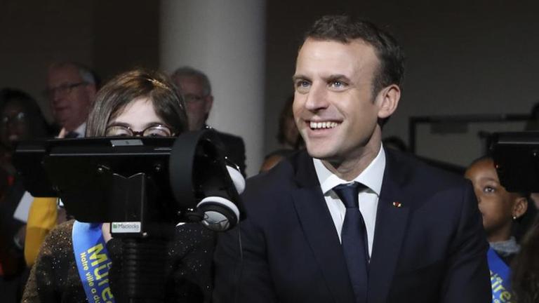 Emmanuel Macron sitzt am 20.2.2018 in der Micro-Folie von Les Mureaux zwischen mehreren Kindern.
