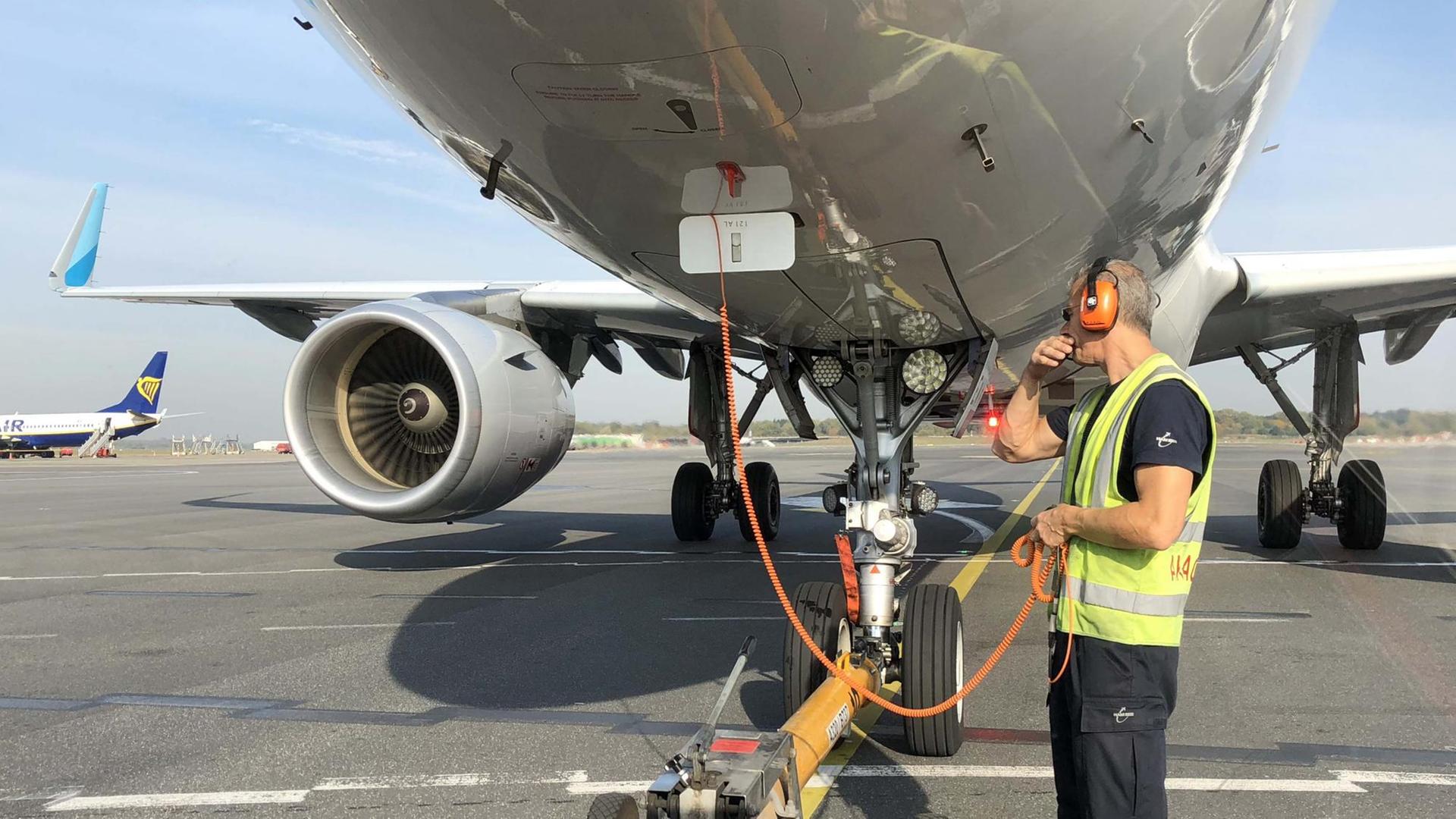 Ein Flugzeug wird auf dem Hamburger Flughafen angekoppelt, um es in die Startposition zu bringen. Ein Flugzeug wird auf dem Hamburger Flughafen angekoppelt, um es in die Startposition zu bringen.
