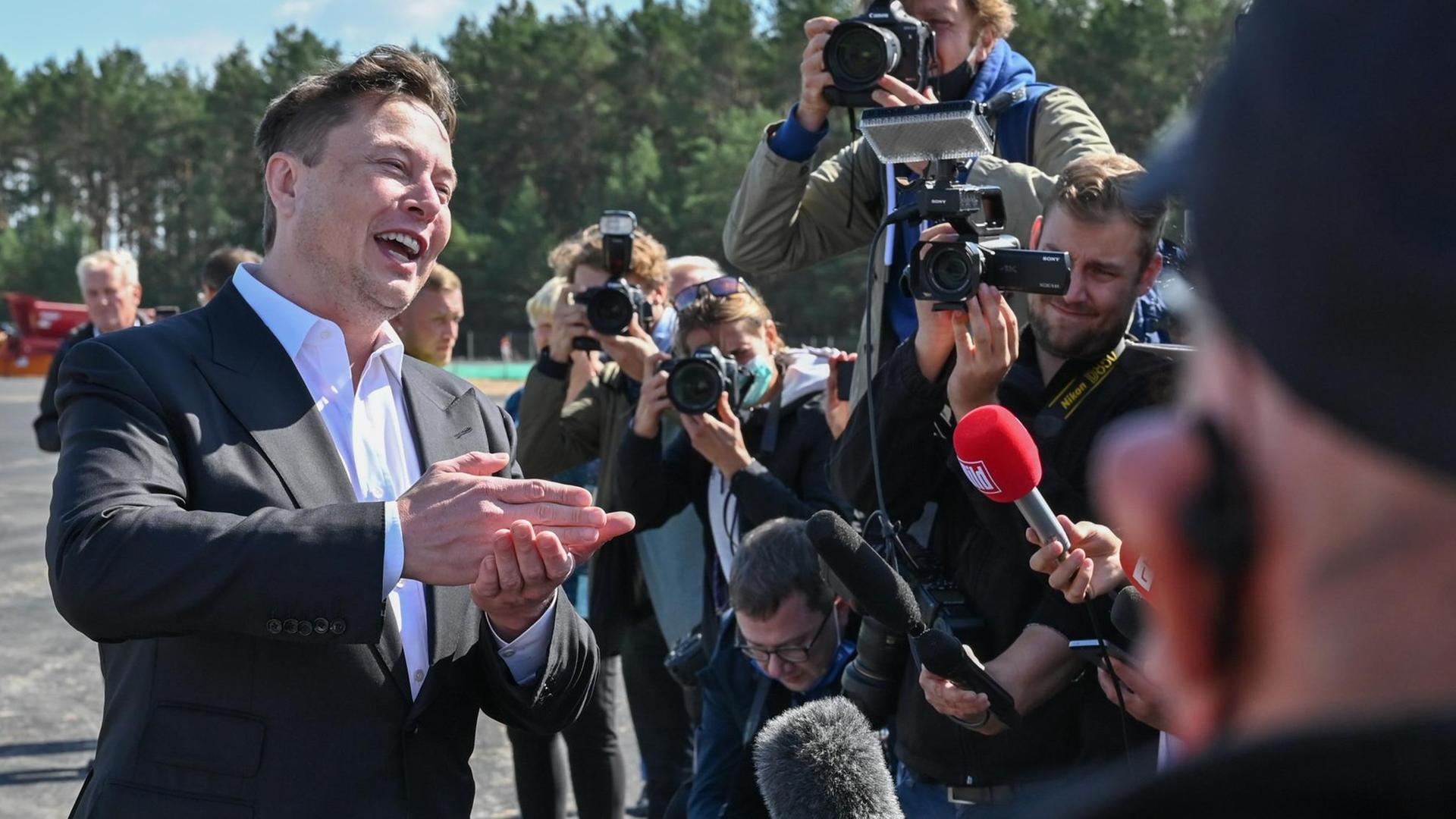 Elon Musk, Tesla-Chef, steht auf der Baustelle der Tesla Gigafactory und unterhält sich mit Journalisten