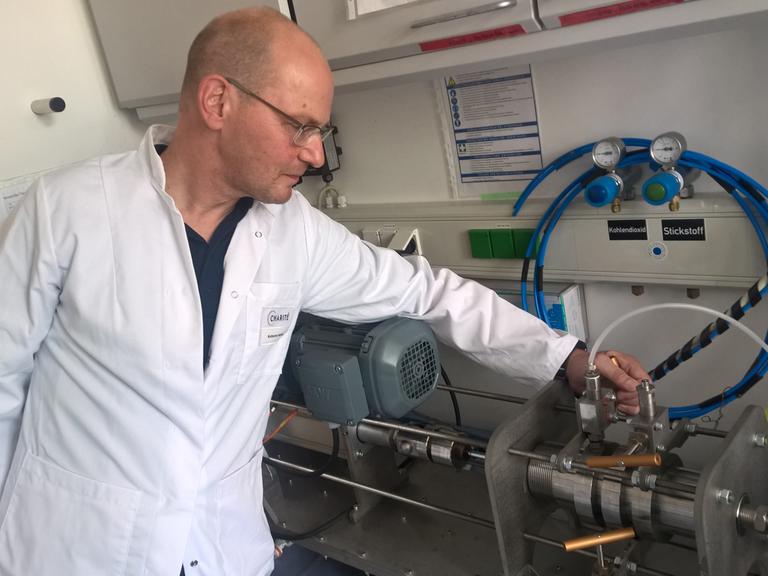 Stefan Hippenstiel an der Wasserstrahl-Schneidemaschine in einem Labor der Charité