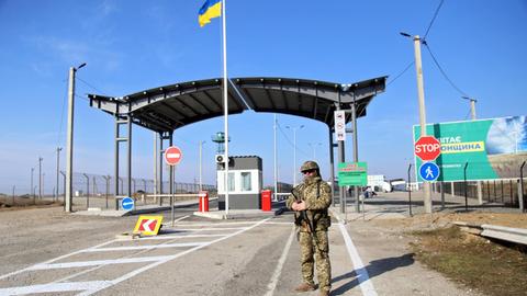Ein bewaffneter Grenzschutzbeamter steht vor dem Kontrollpunkt Chonhar an der Verwaltungsgrenze zwischen der Region Kherson und der besetzten Krim am 15. November 2019.