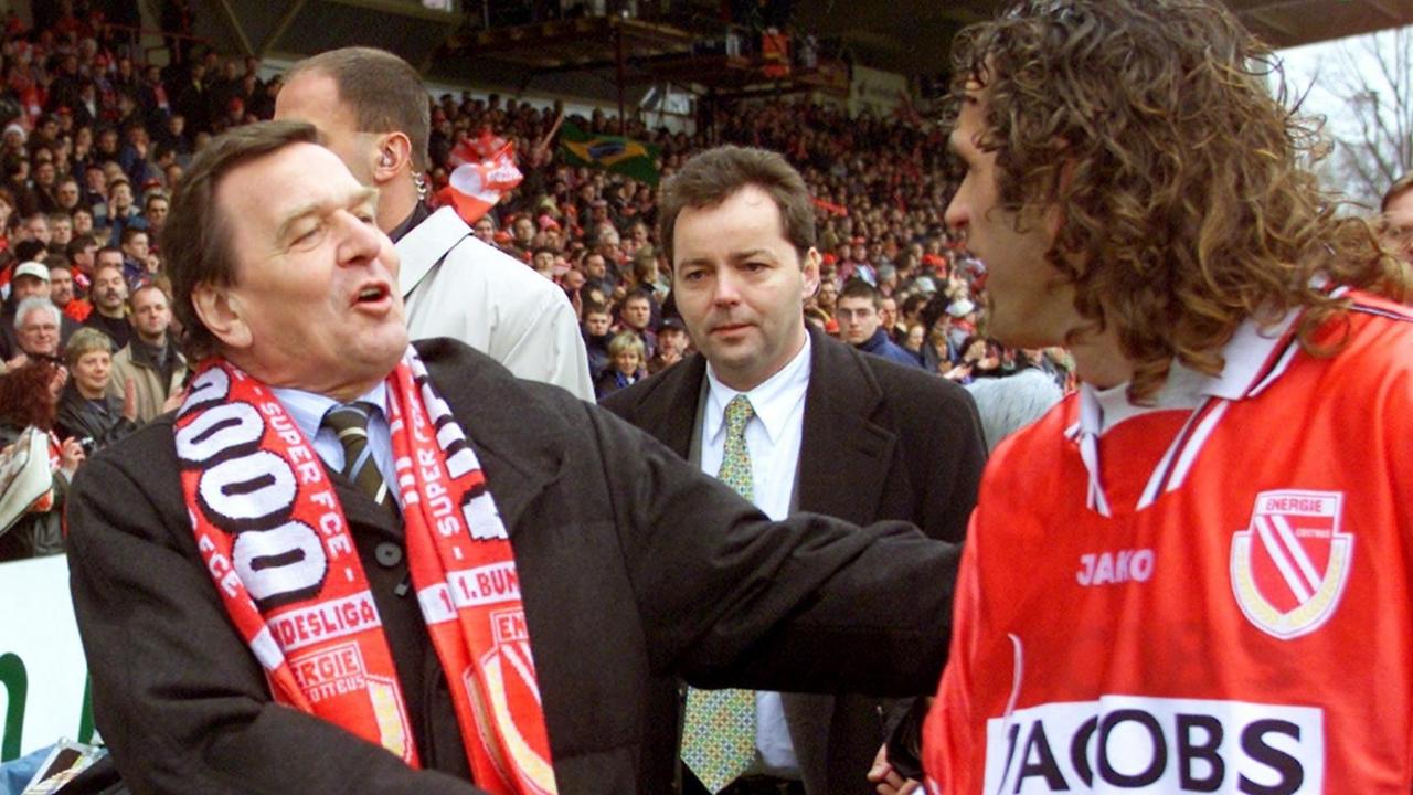 Überschwänglich gratuliert Bundeskanzler Gerhard Schröder (l.) am 21.4.2001 dem Spieler von Energie Cottbus, Bruno Akrapovic, zum 1:0-Sieg im Abstiegsduell gegen die SpVgg Unterhaching.