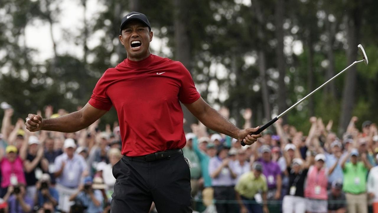 Tiger Woods freut sich über seinen fünften Masters-Sieg. Im Hintergrund jubeln die Zuschauer am Grün.