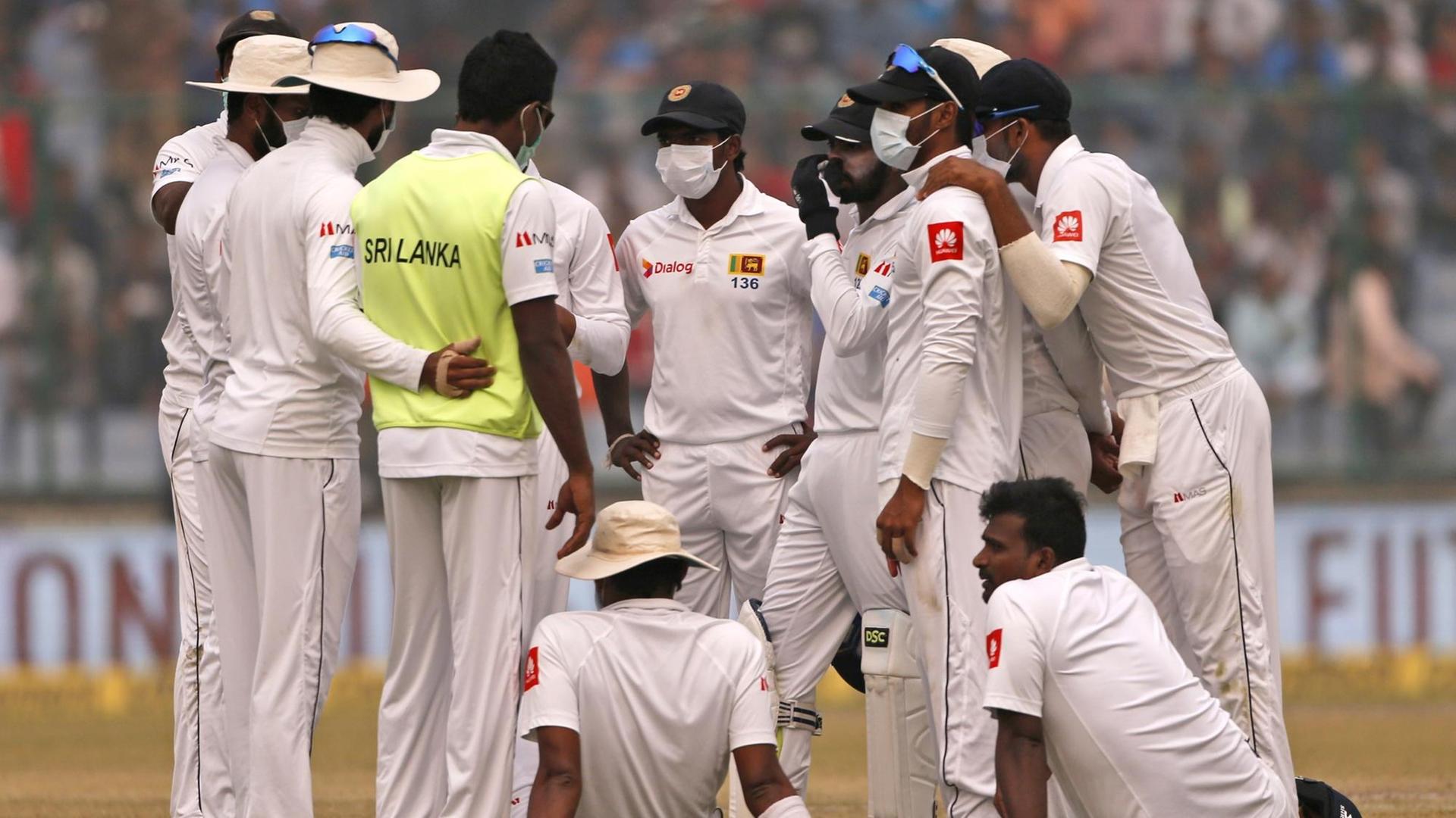 Cricket-Nationalspieler von Sri Lanka tragen beim Testspiel gegen Indien Schutzmasken wegen des Smogs in Neu-Delhi.