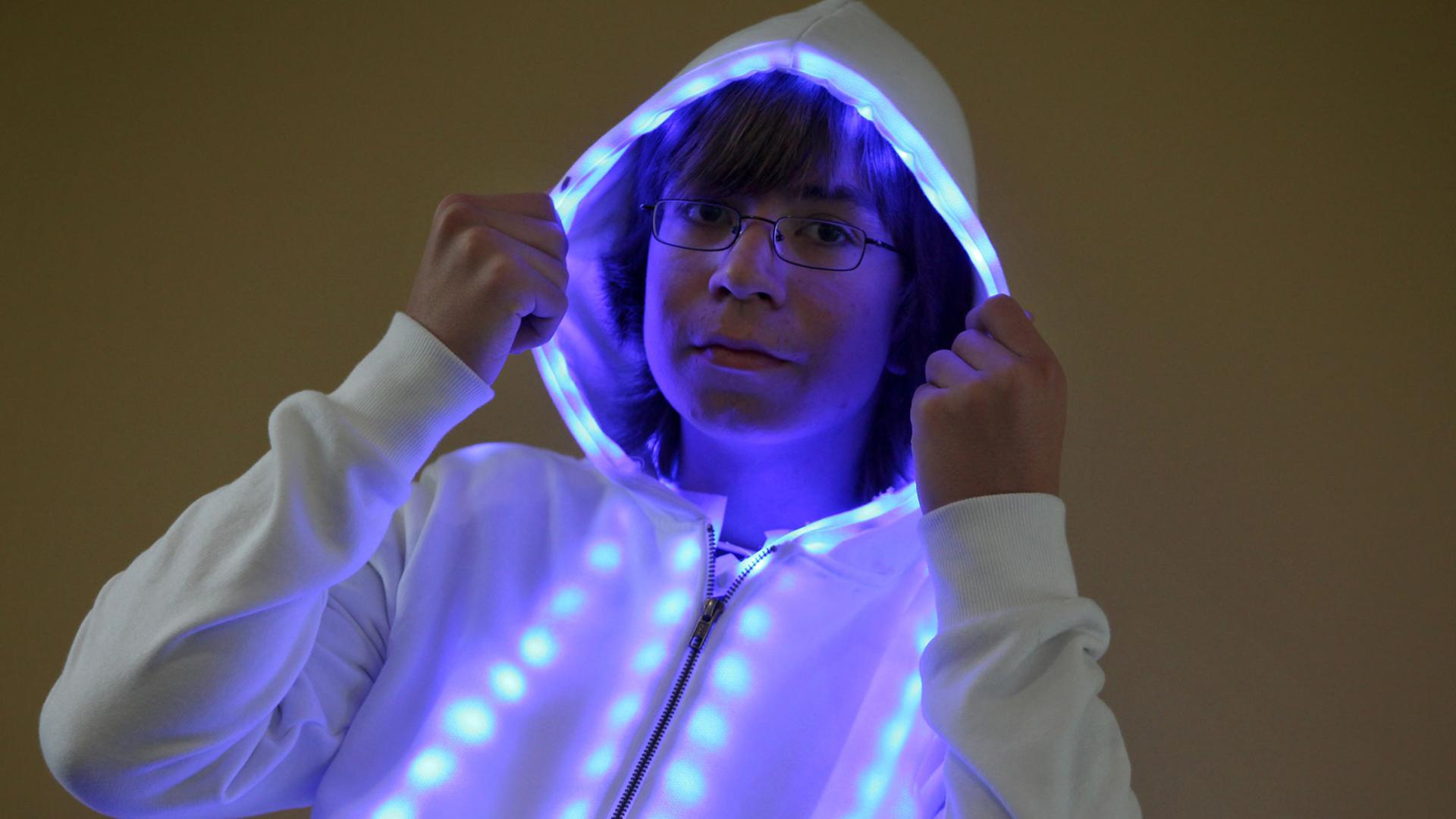 Ein Schüler trägt einen Pullover mit LED-Kette, die die Farbe verändern kann.