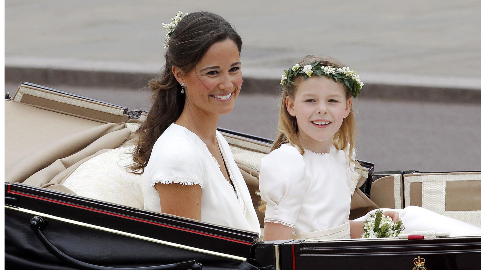 Zu sehen ist Pippa Middleton, die Schwester der britischen Herzogin Kate, nach deren Hochzeit am 29. April 2011. Pippa sitzt in einer offenen Kutsche, einem Landauer. Begleitet wird sie von einem Kind, dem Blumenmädchen Margarita Armstron-Jones. Sie sind auf dem Weg zum Buckingham Palace in London.