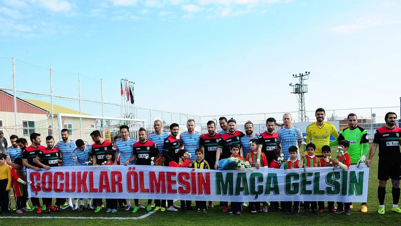 Die Spieler des kurdischen Fußballvereins Amedspor aus Diyarbakir halten vor dem Match mit dem Klub Fenerbahce in Istanbul ein Transparent auf dem auf türkisch steht "Kinder sollten nicht sterben, sondern zu Fußballspielen gehen". 