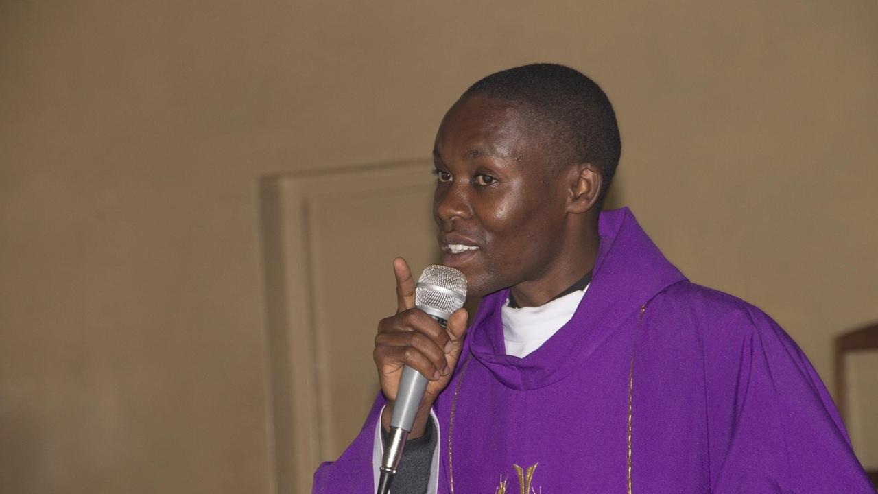 Pater Douglas im violetten Gewand bei der Predigt.