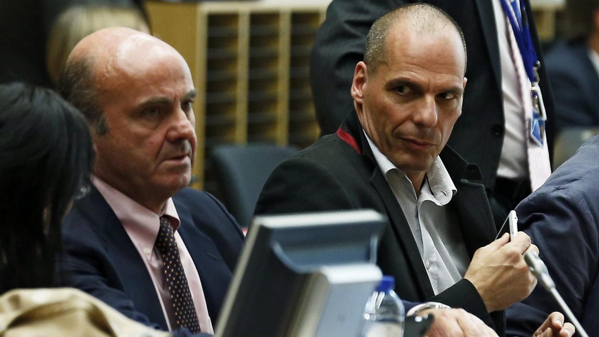 Der spanische Wirtschaftsminister Luis de Guindos (l) und der griechische Finanzminister Giannis Varoufakis nebeneinander am Verhandlungstisch.