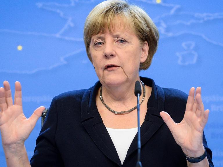 Angela Merkel spricht an einem Rednerpult und gestikuliert mit den Händen.