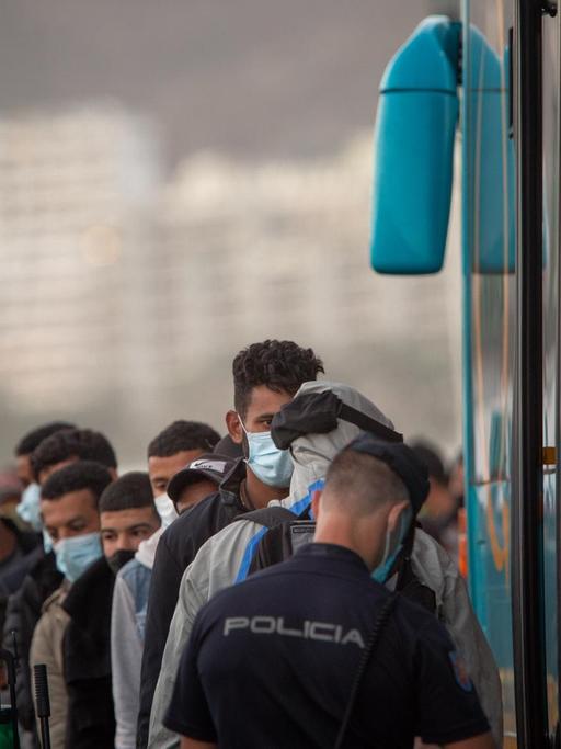 Rund 500 Migranten aus einer Gruppe von 1334, die aus verschiedenen Booten gerettet wurden, warten darauf, vom Hafen von Arguineguin in die Notunterkünfte des Roten Kreuzes gebracht zu werden, wo sie vom spanischen Roten Kreuz und der nationalen Polizei in Mogan auf den spanischen Kanaren betreut werden Insel Gran Canaria am 20. November 2020.