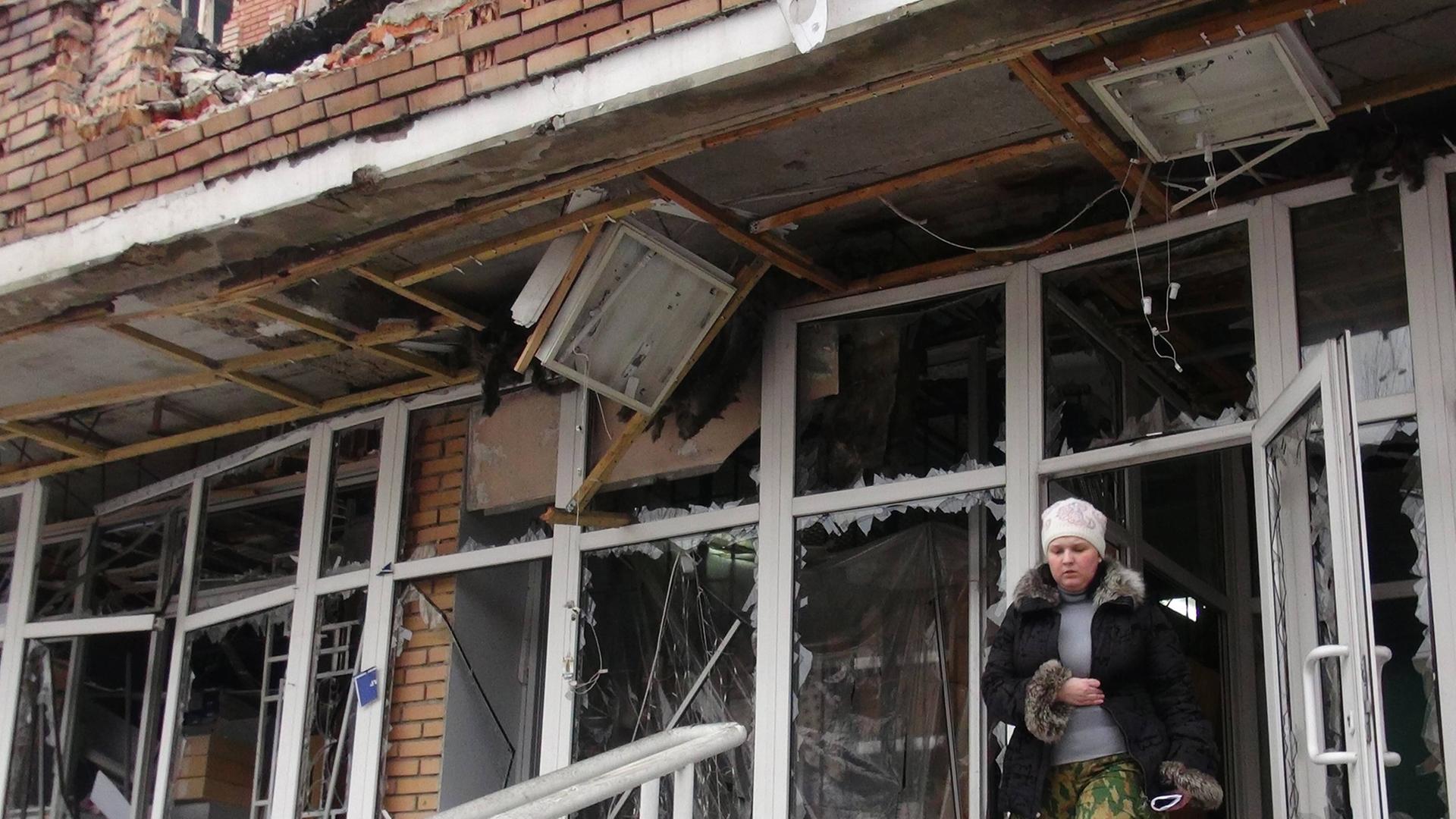 Ein Frau verlässt das getroffene Krankenhaus in Donezk