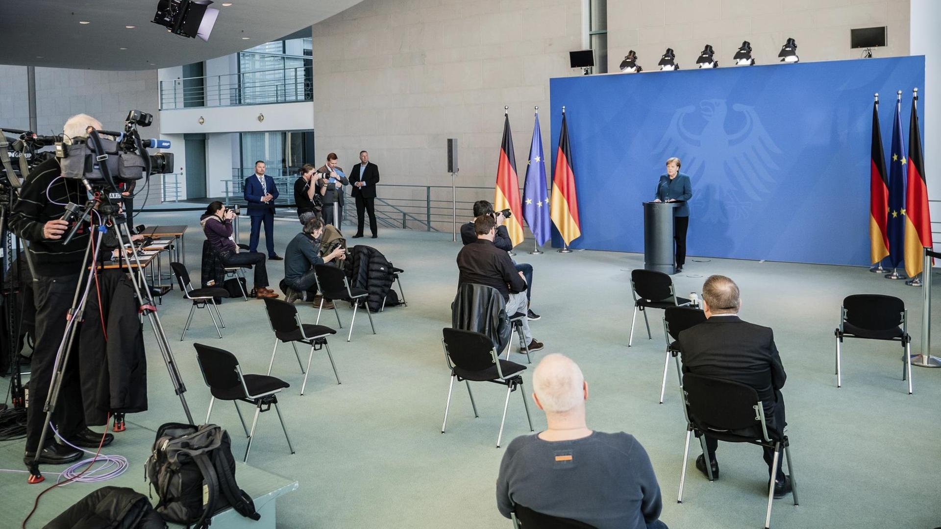 Bundeskanzlerin Merkel spricht auf einer Pressekonferenz zu Journalisten, die weit entfernt voneinander sitzen.