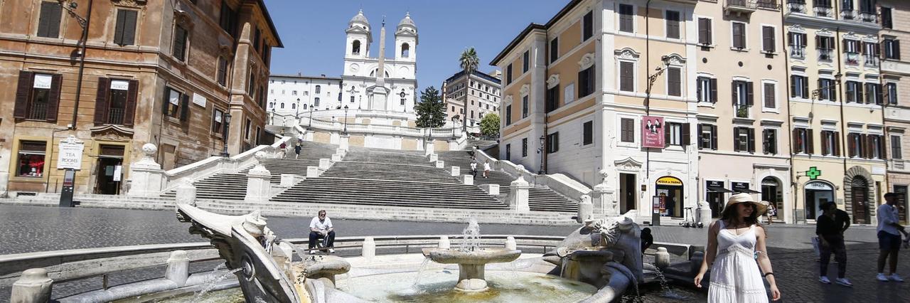 Einzelne Touristen stehen am Brunnen «Fontana della Barcaccia» vor der Spanischen Treppe in Rom, einem der Touristen-Hotspots.