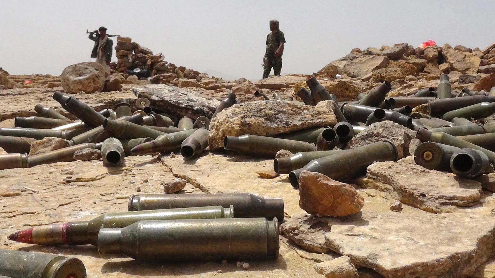 Bewaffnete jemenitische Anhänger des geflohenen Präsidenten Hadi stehen hinter zahlreichen Artilleriehülsen.