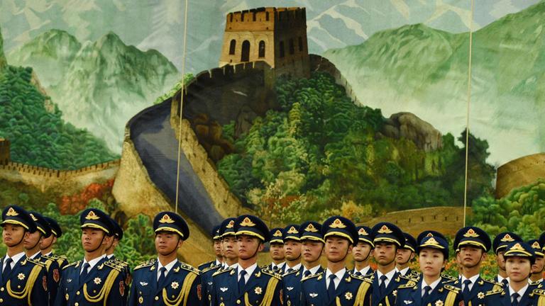 Chinesische Soldaten stehen am 13.06.2016 in der Großen Halle des Volkes in Peking (China) vor Beginn der militärischen Ehren für die Bundeskanzlerin vor einem Bild der Chinesischen Mauer. Merkel ist zu einem dreitägigen Besuch in China.