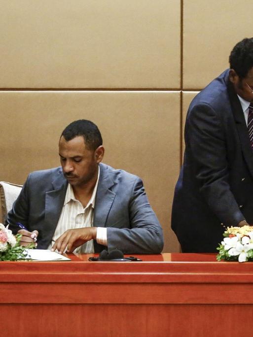 General Mohamed Hamdan Daglo (r.) vom regierenden Übergangs-Militärrat und Ahmed Rabie von der prodemokratischen Protestbewegung unterzeichnen am 4. August 2019 ein Verfassungspapier, um den Weg zu einer Zivilregierung im Sudan freizumachen