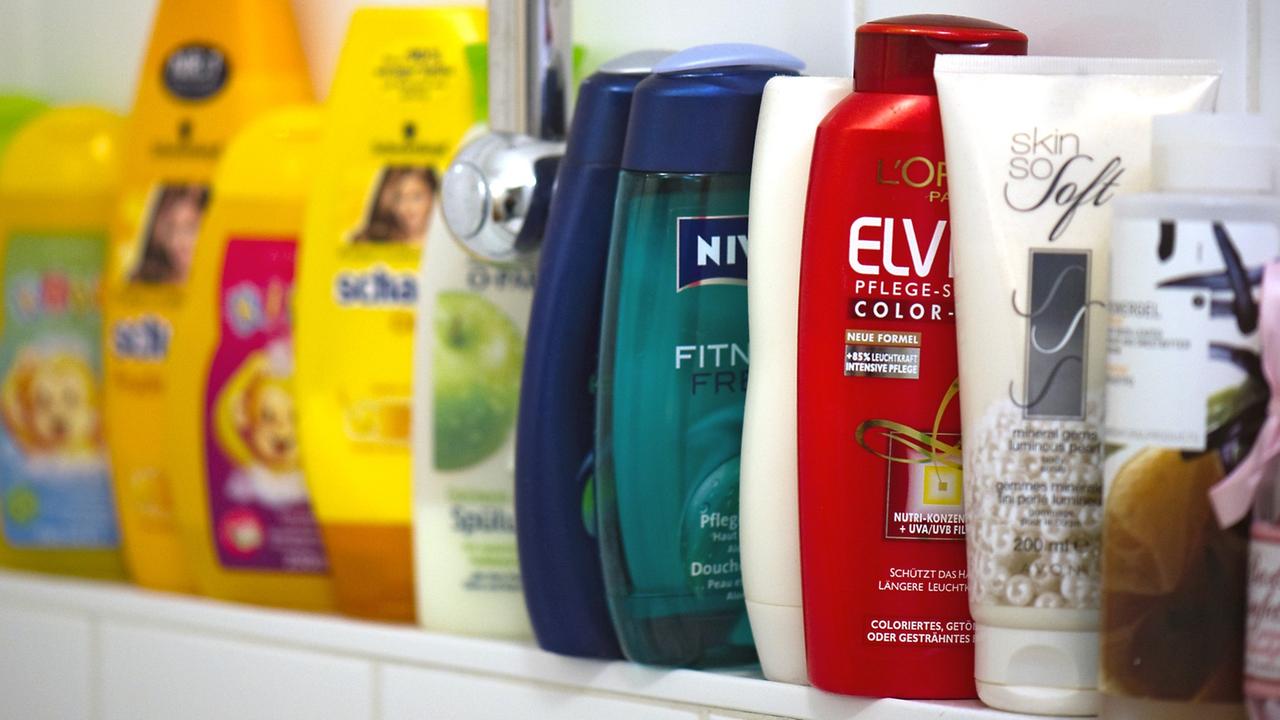 Körperpflege-Produkte stehen in einer Reihe auf einem Badewannenrand.