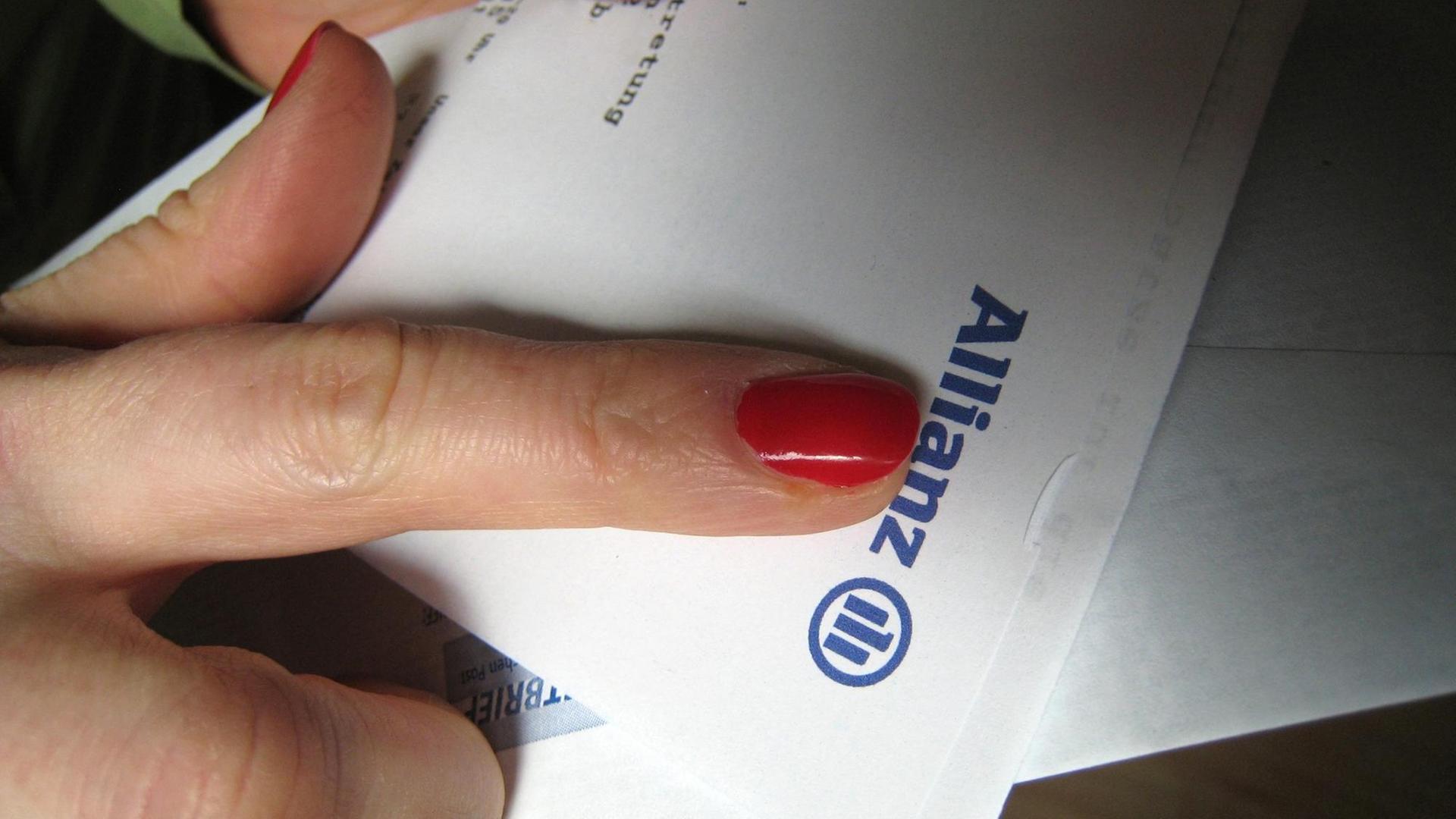 Zu sehen ist ein Finger, der auf einen Brief der Allianz zeigt.