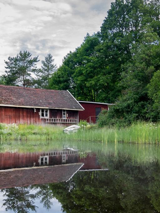 Eine schwedische Holzhütte an einem See.