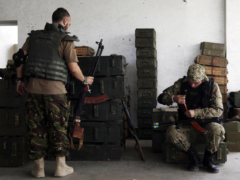 Ukrainische Soldaten reinigen ihre Gewehre.