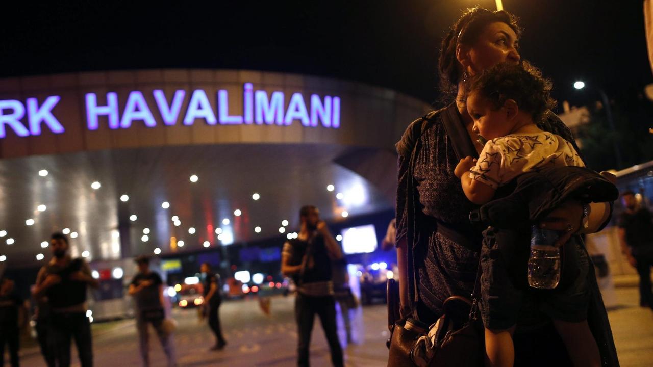 Nach dem Selbstmordanschlag am Atatürk-Flughafen in Istanbul haben die Menschen das Gebäude verlassen und spenden sich Trost