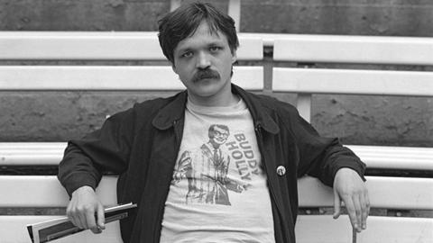 Wolfgang Welt mit Schnauzbart sitzt 1981 auf einer Parkbank.