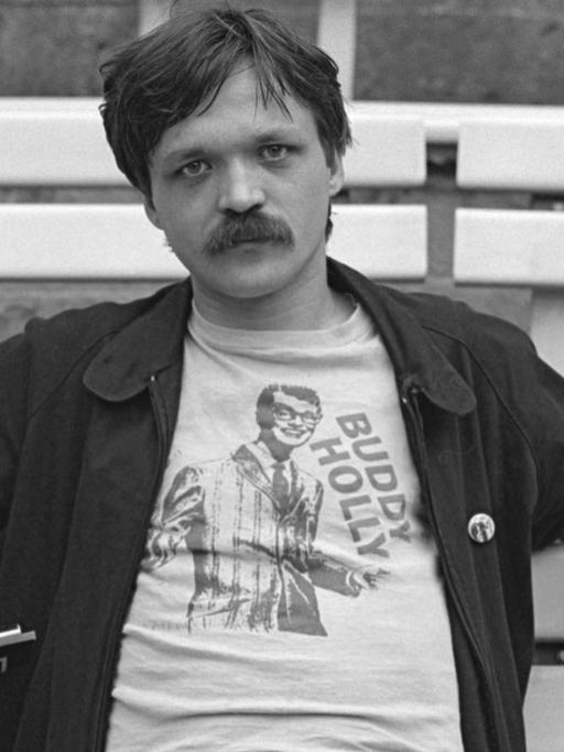 Wolfgang Welt mit Schnauzbart sitzt 1981 auf einer Parkbank.