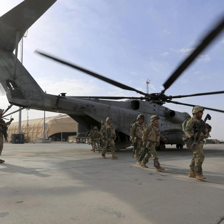US-Marines bei einem Einsatz im Nahen Osten: Ein Hubschrauber landet gerade, mehrere Soldaten befinden sich auf dem Flugplatz.