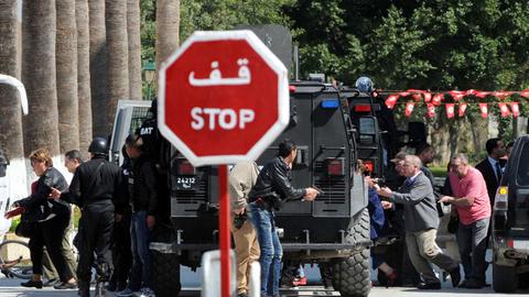 Sicherheitskräfte und andere Menschen laufen aus dem Nationalmuseum in Tunis.