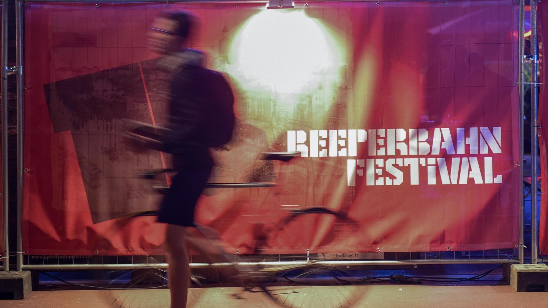 Ein Passant schiebt am 20.09.2017 in Hamburg vor dem Theater "Schmidtchen" sein Fahrrad vor dem Logo des Reeperbahn Festivals entlang. Das Festival findet vom 20. bis 23. September 2017 in der Hansestadt statt.