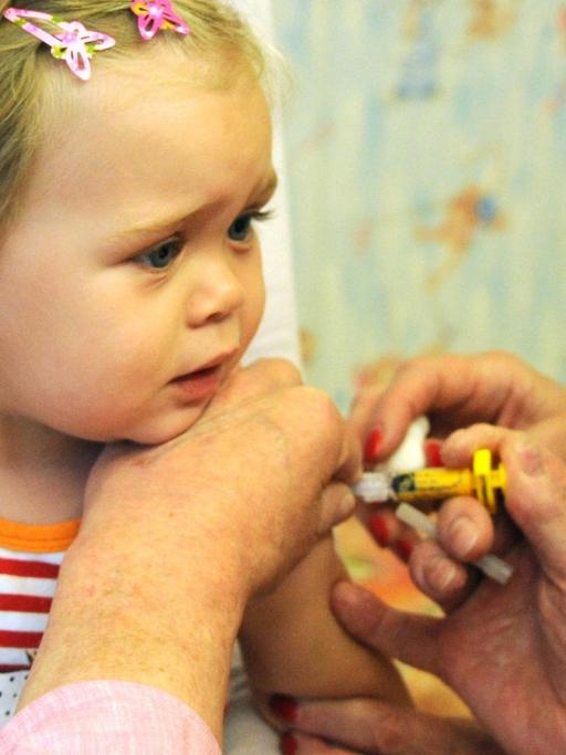 Der Kinder-und Jugendarzt Dr. Klaus Schwieger impft in seiner Praxis in Leipzig ein 21 Monate altes Kleinkind