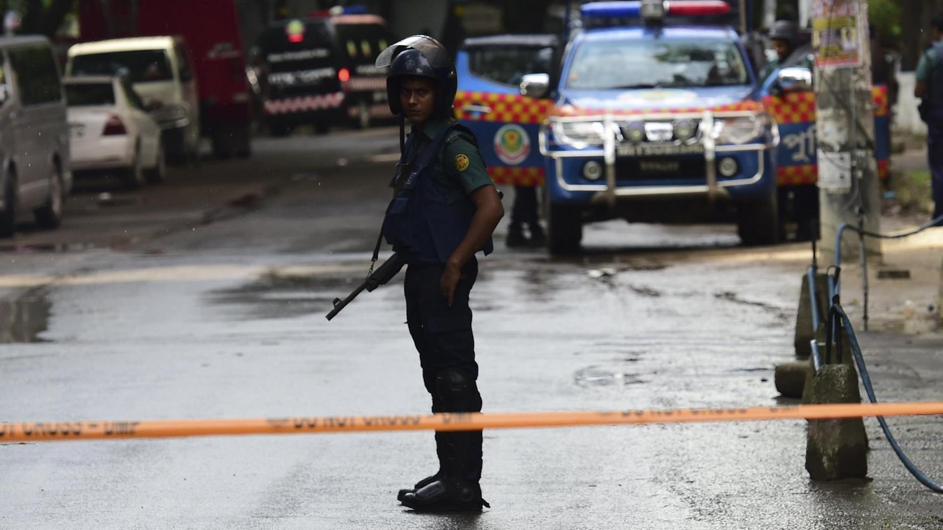 A Bangladeshi security personal stands guard during a rescue operation as gunmen take position in a restaurant in the Dhakas high-security diplomatic district on July 2, 2016 where several people including foreigners are believed to be trapped. Thirteen hostages have been rescued after security forces ended a siege at a cafe in the Bangladeshi capital Dhaka, a top commander said. / AFP PHOTO / APF / STR
